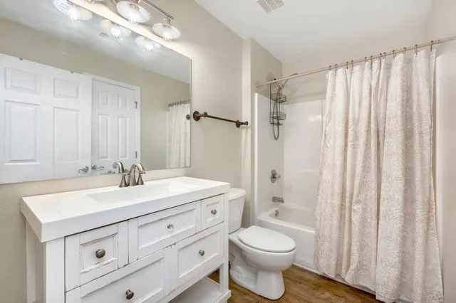 a bathroom with a sink a toilet a mirror and shower