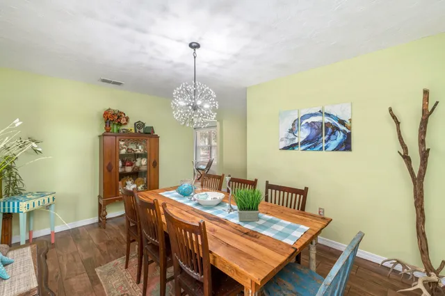 a view of a dining room with furniture a chandelier and wooden floor