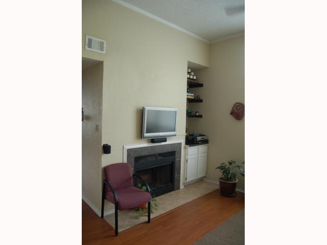 2804 Rio Grande Street, Unit 307 Austin, TX 78705 - Photo 4 of 14 Living area featuring crown molding, light wood finished floors, and a tiled fireplace
