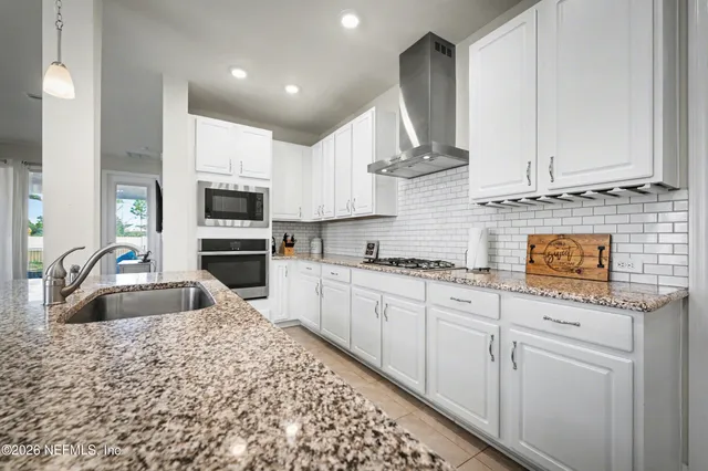 a kitchen with stainless steel appliances granite countertop a sink a stove and cabinets