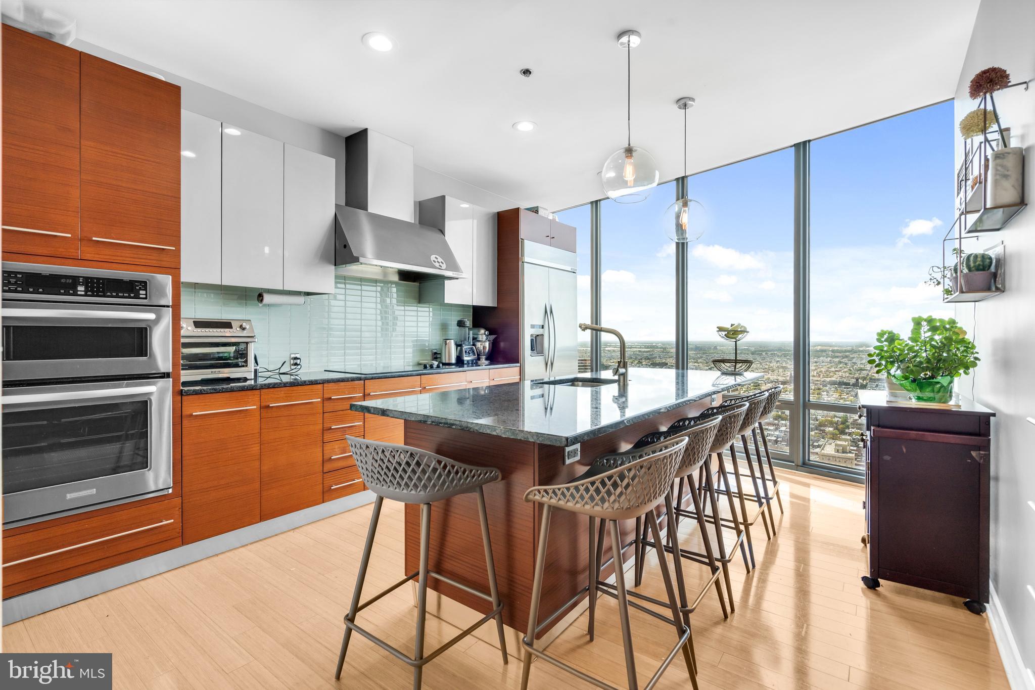 2101 Market Street, Unit PH02 Philadelphia, PA 19103 - Photo 11 of 56 a kitchen with stainless steel appliances granite countertop wooden floor a stove a sink and a refrigerator