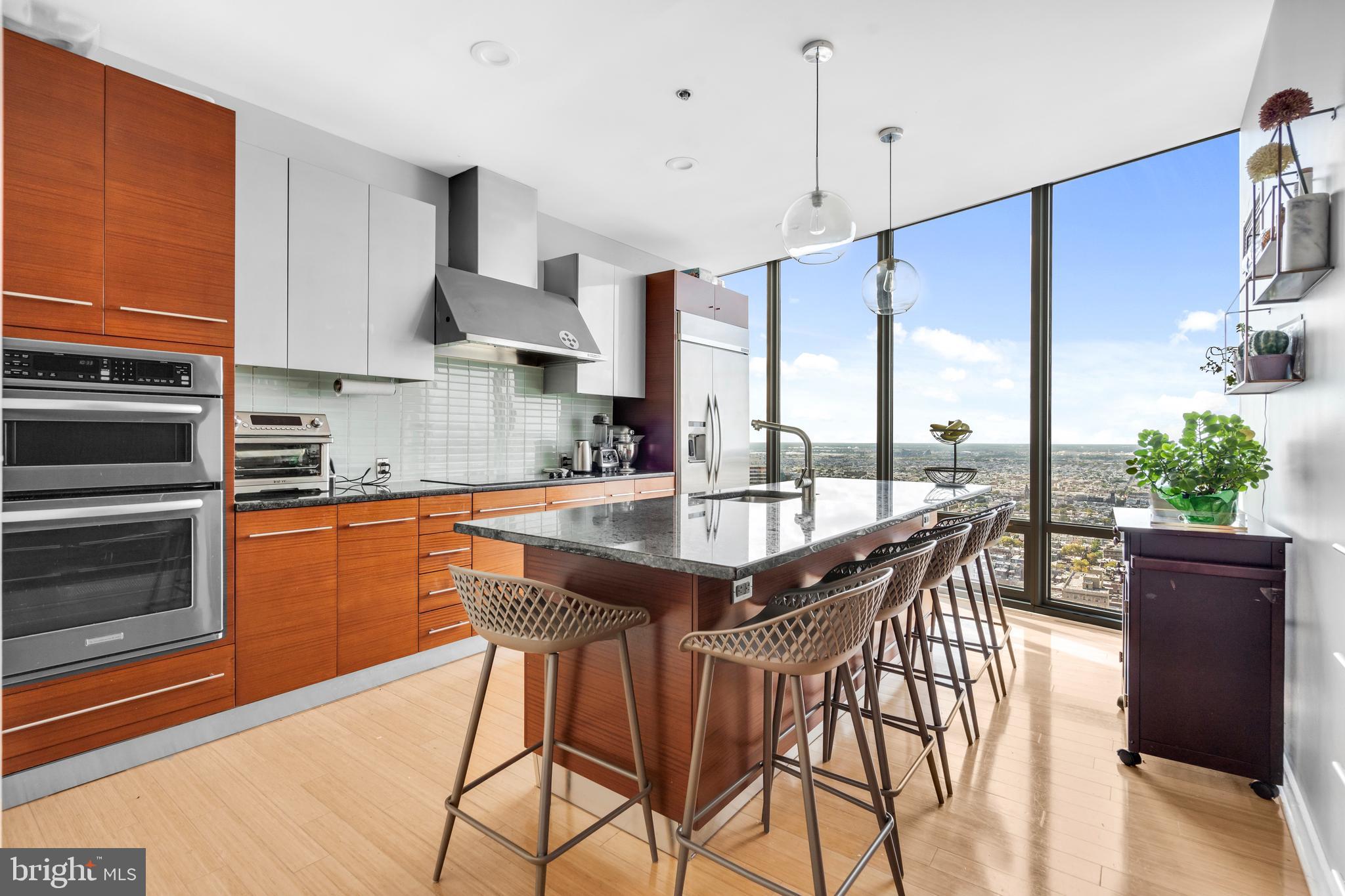 2101 Market Street, Unit PH02 Philadelphia, PA 19103 - Photo 12 of 56 a kitchen with stainless steel appliances granite countertop wooden floor a stove a sink and a refrigerator