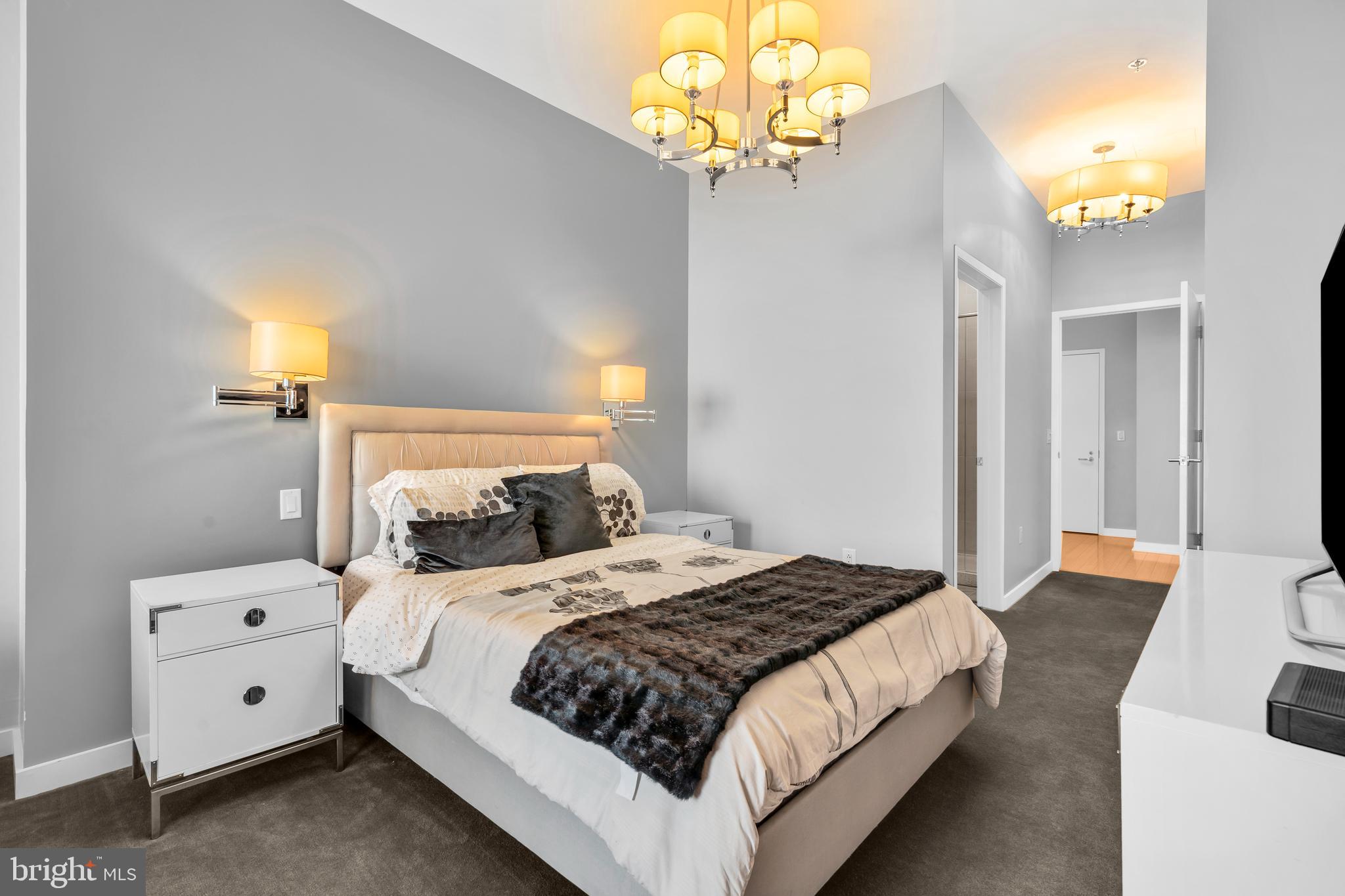 2101 Market Street, Unit PH02 Philadelphia, PA 19103 - Photo 24 of 56 a bedroom with a bed and a chandelier