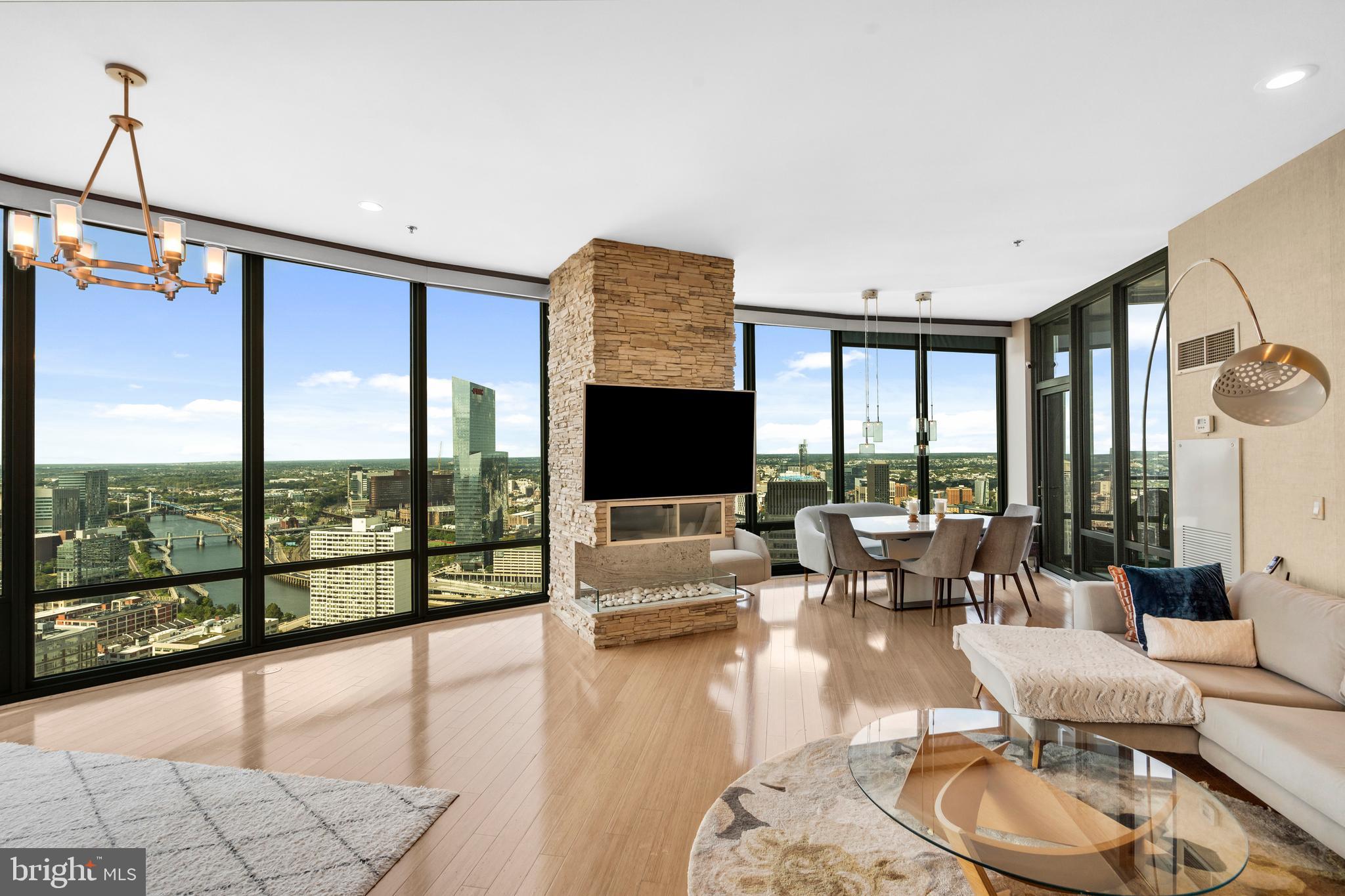 2101 Market Street, Unit PH02 Philadelphia, PA 19103 - Photo 3 of 56 a living room with fireplace furniture and floor to ceiling windows