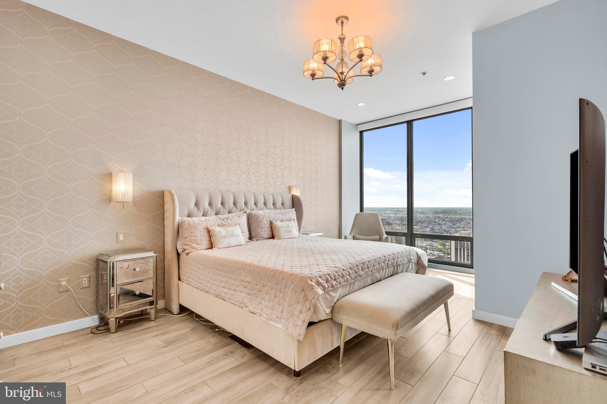 2101 Market Street, Unit PH02 Philadelphia, PA 19103 - Photo 33 of 56 a bedroom with a bed chandelier and a window