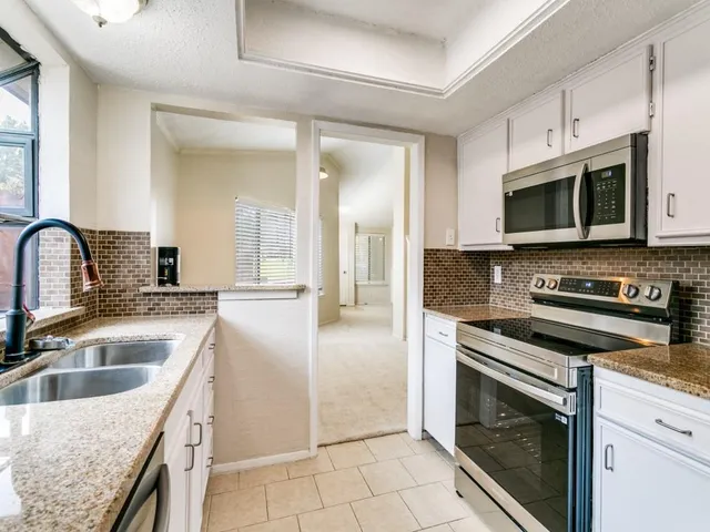 a kitchen with stainless steel appliances granite countertop a sink stove and microwave