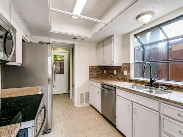 a kitchen with stainless steel appliances granite countertop a sink and a stove