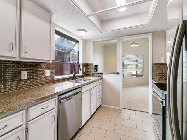 a kitchen with stainless steel appliances granite countertop a sink and cabinets