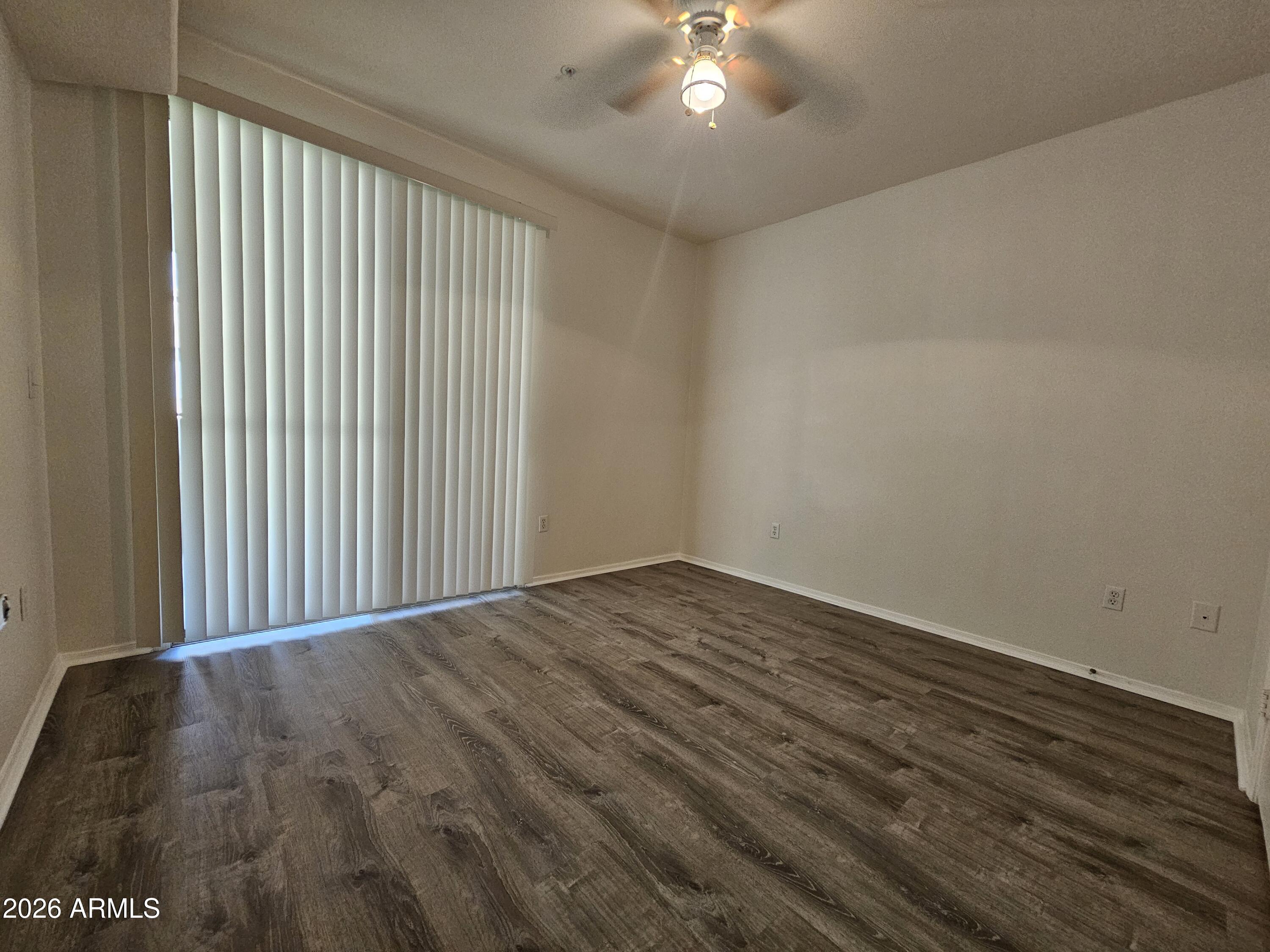 18416 North Cave Creek Road, Unit 1075 Phoenix, AZ 85032 - Photo 5 of 14 en empty room with wooden floor and chandelier fan