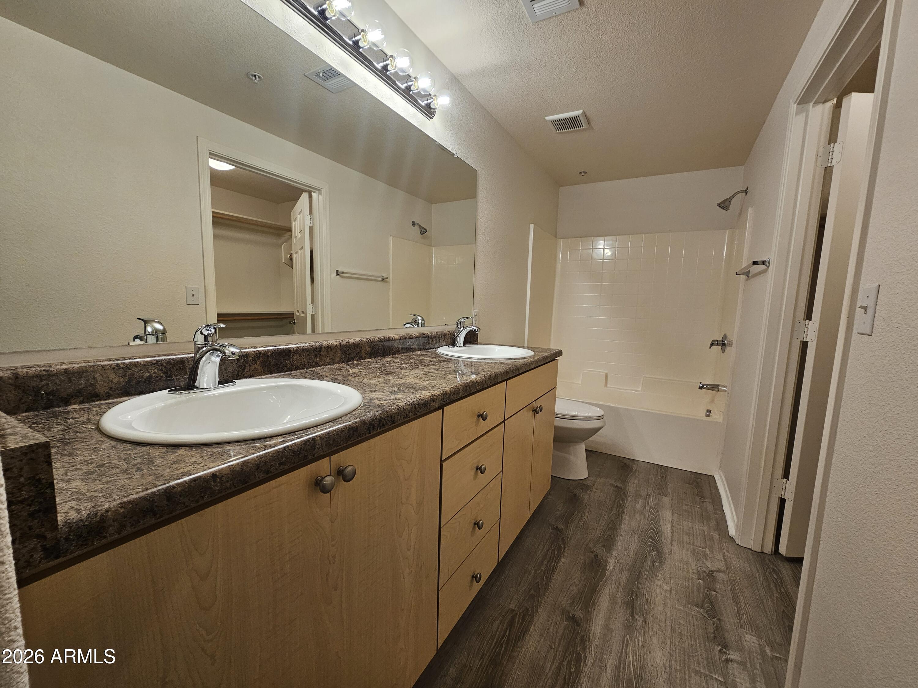 18416 North Cave Creek Road, Unit 1075 Phoenix, AZ 85032 - Photo 6 of 14 a spacious bathroom with a granite countertop sink a mirror and a toilet