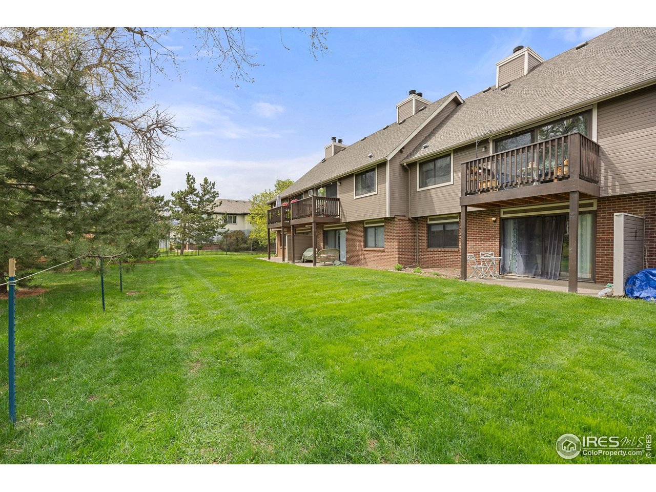 1231 West Swallow Road, Unit 314 Fort Collins, CO 80526 - Photo 21 of 29 a view of a house with a big yard and large trees