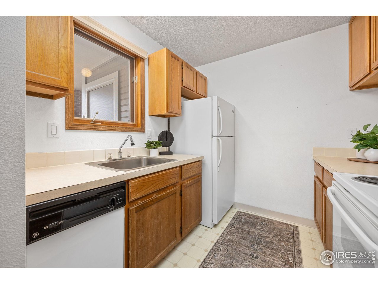 1231 West Swallow Road, Unit 314 Fort Collins, CO 80526 - Photo 7 of 29 a kitchen with a sink and a refrigerator