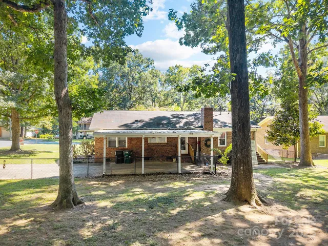 a view of a house with a backyard and a tree