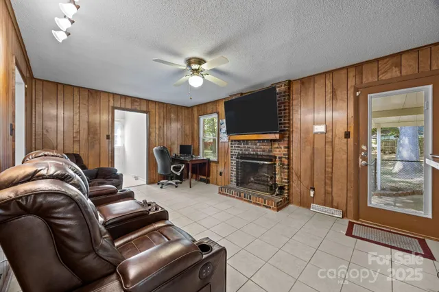 a living room with furniture a fireplace and a chandelier