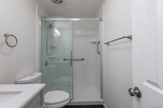 a bathroom with a toilet and a shower