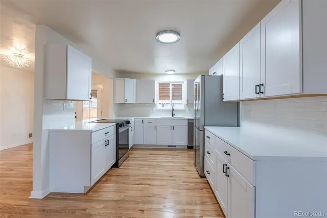 a kitchen with granite countertop white cabinets and white appliances