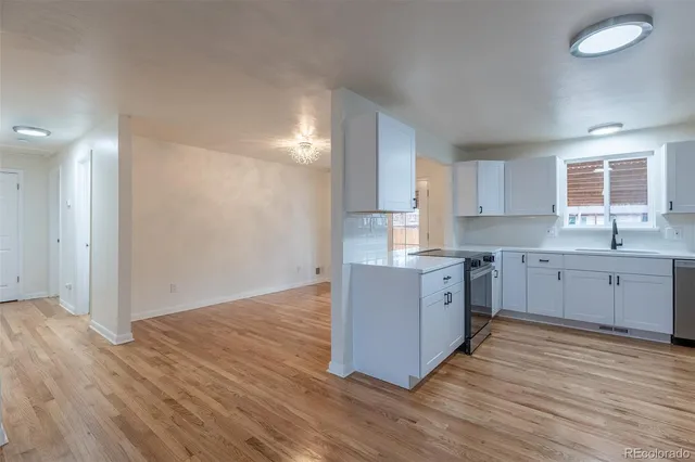 a large kitchen with a wooden floor and window