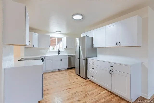 a kitchen with white cabinets and white appliances