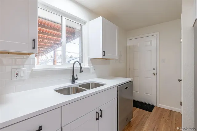 a kitchen with a sink and wooden floor
