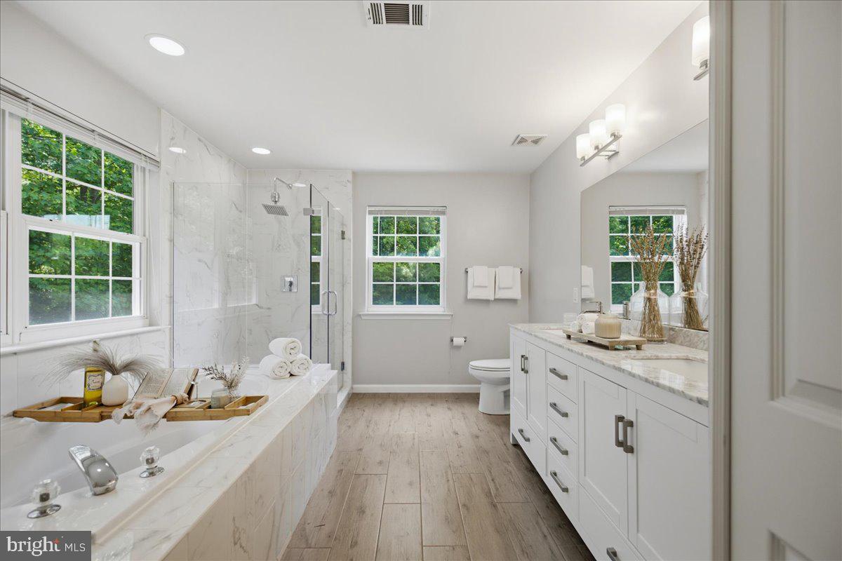 2424 Springbrook Court Huntingtown, MD 20639 - Photo 54 of 103 a bathroom with a granite countertop sink mirror bathtub and next to a window
