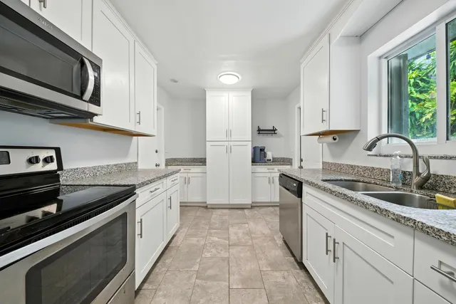 a kitchen with stainless steel appliances granite countertop a sink stove and microwave