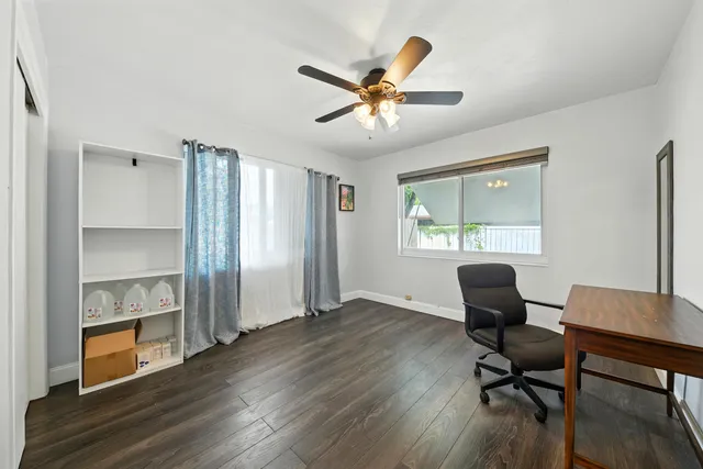 a view of a livingroom with a ceiling fan and wooden floor