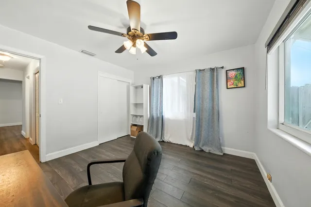 a view of a workspace with wooden floor and a window