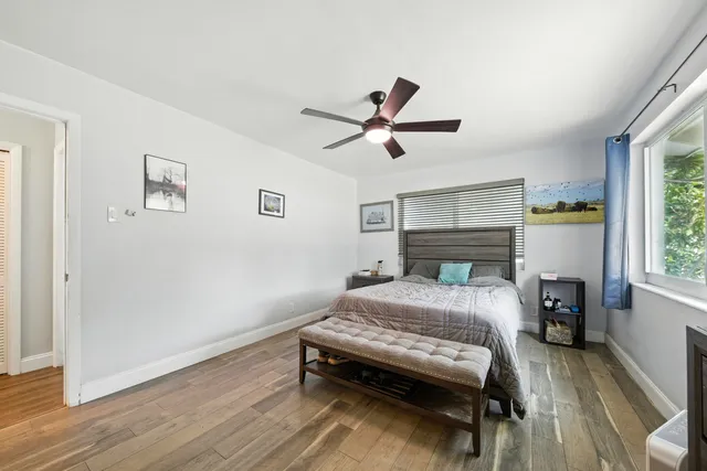 a bedroom with a bed and a ceiling fan