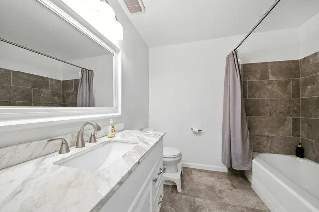 a bathroom with a tub a sink and mirror