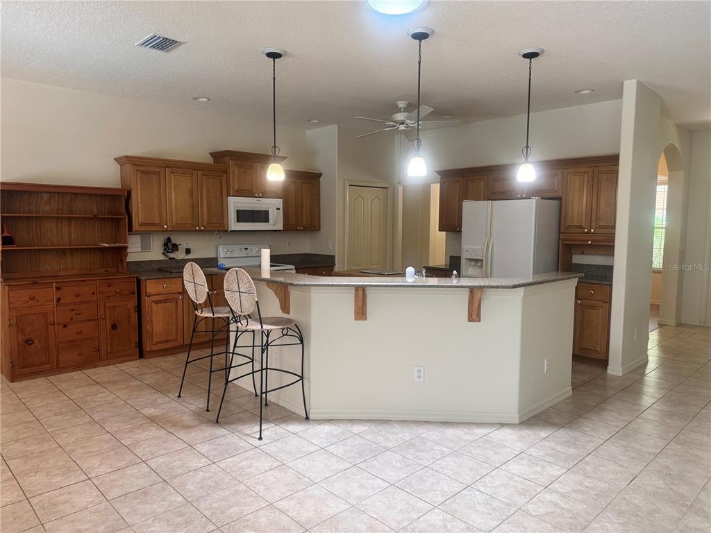 11145 Northwest 17th Court Road Ocala, FL 34475 - Photo 24 of 59 a kitchen with kitchen island a counter top space appliances and a chandelier