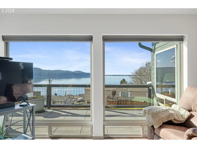 a living room with couches chairs and a floor to ceiling window