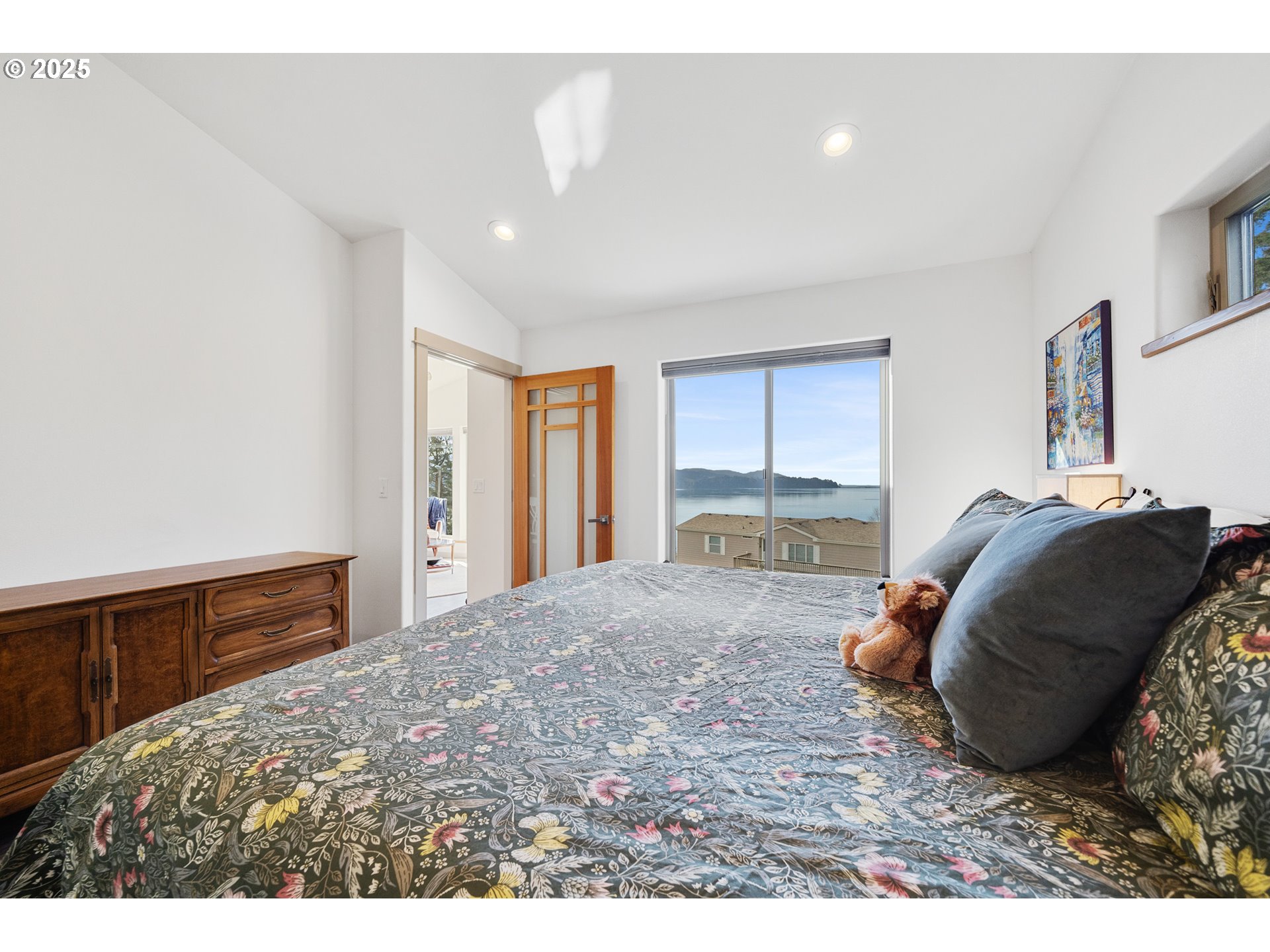 9065 8th Street Bay City, OR 97107 - Photo 22 of 48 a bedroom with a large bed and wooden floor