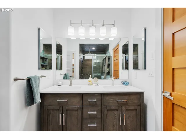 a bathroom with a granite countertop sink a large mirror and a shower