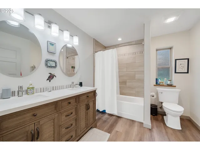 a bathroom with a double vanity sink mirror and toilet