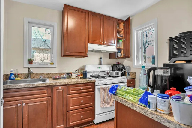 a kitchen with granite countertop lots of clutter and stainless steel appliances