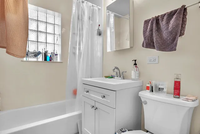 a bathroom with a sink toilet vanity and tub