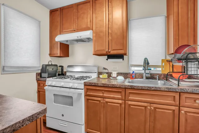 a kitchen with stainless steel appliances granite countertop a sink stove and cabinets