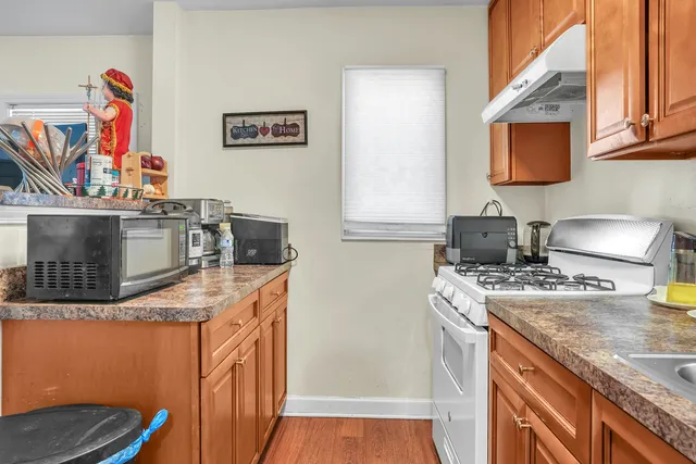 a kitchen with stainless steel appliances granite countertop a stove a sink and a microwave
