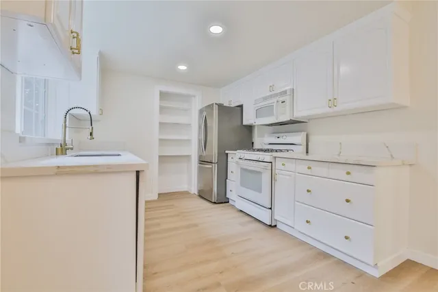 a kitchen with white cabinets and white appliances