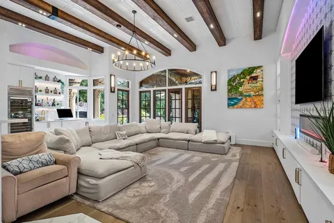 a living room with patio furniture and potted plants