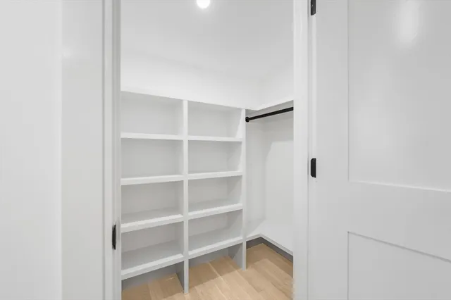 a view of walk in closet with empty racks