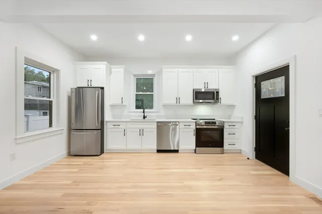 a kitchen with stainless steel appliances granite countertop a refrigerator and a stove top oven
