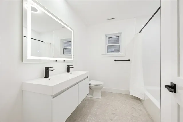 a bathroom with a sink toilet and mirror
