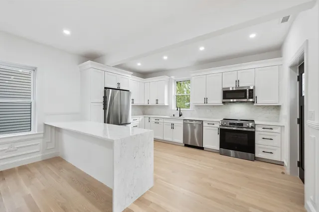 a kitchen with stainless steel appliances granite countertop a refrigerator and a stove top oven