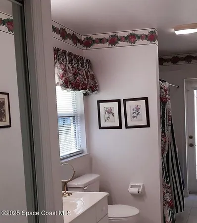 a bathroom with a toilet a sink and mirror