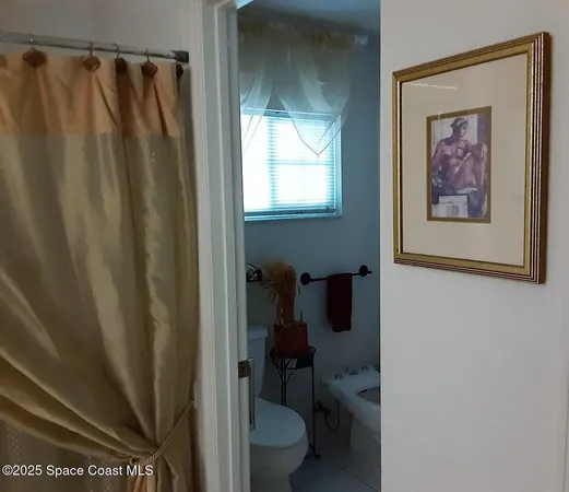 a bathroom with a toilet and a shower curtain