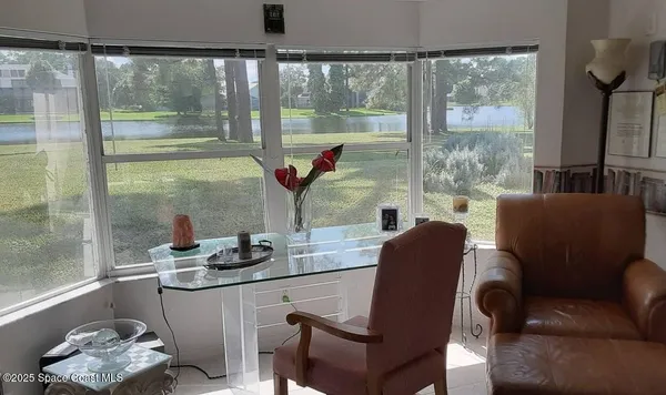 a dining room with furniture and a floor to ceiling window