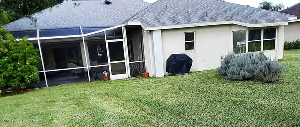a view of house with backyard and front door