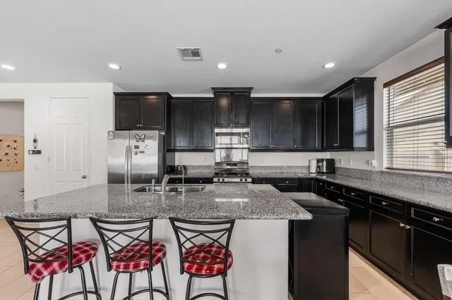 a kitchen with stainless steel appliances granite countertop a sink stove and microwave