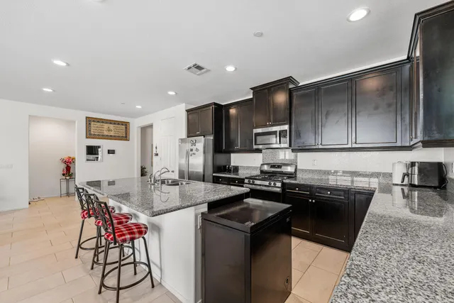 a kitchen with stainless steel appliances granite countertop a sink stove and refrigerator